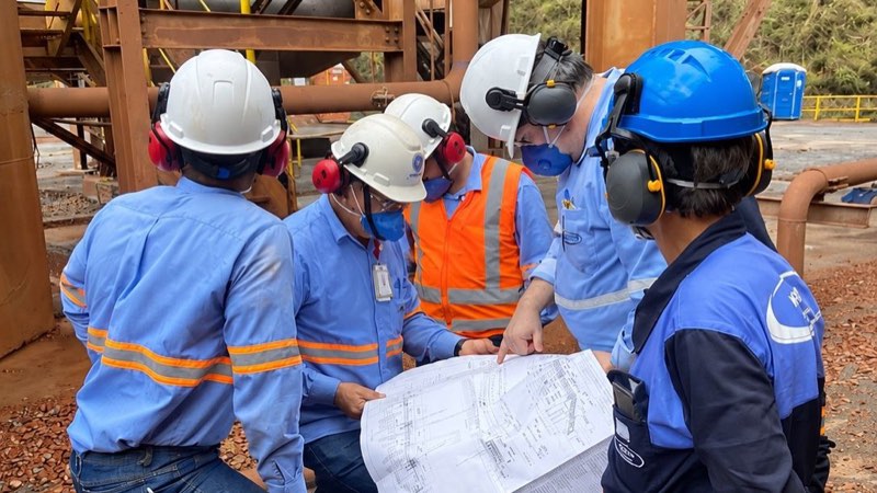 Equipe da Kesco e do cliente analisando um desenho técnico em planta industrial