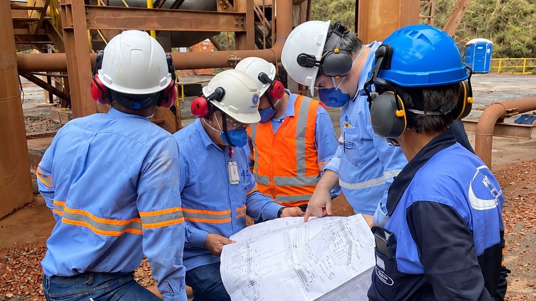 Equipe da Kesco e do cliente analisando um desenho técnico em planta industrial