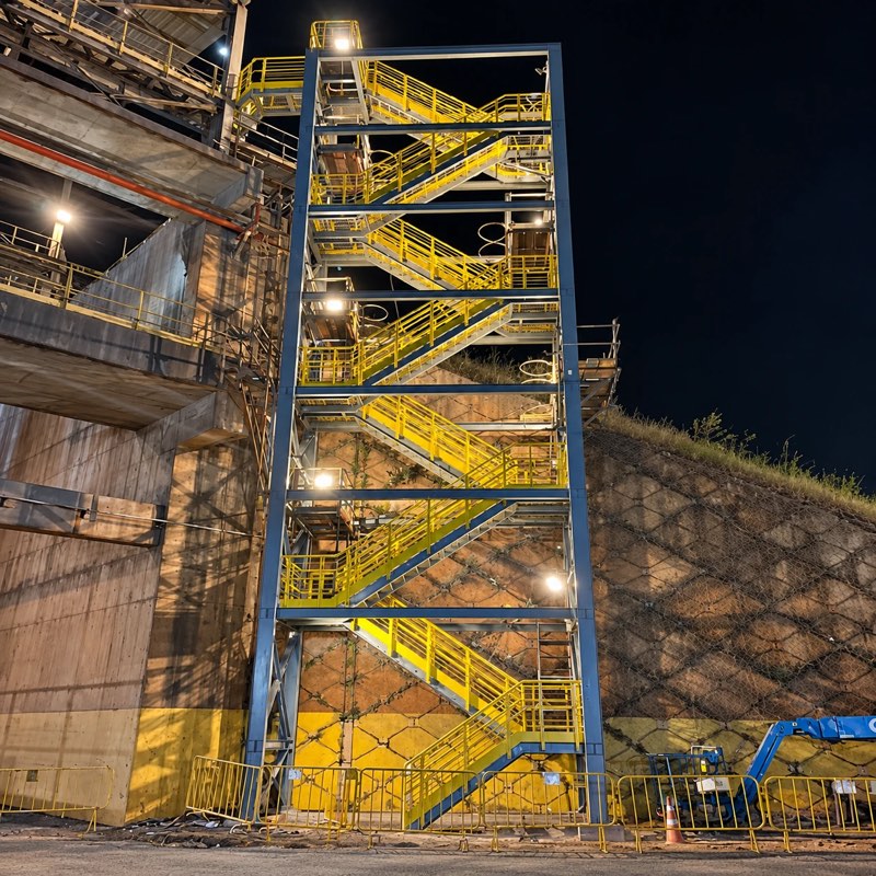 Torre de escadas metálica iluminada durante trabalho noturno